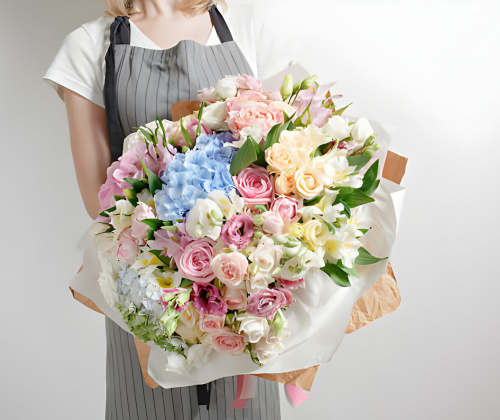 Persona con delantal sostiene un ramo de flores